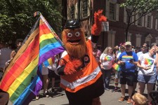 Image of Philly Flyers mascot Gritty holding the Philadelphia Pride Flag.